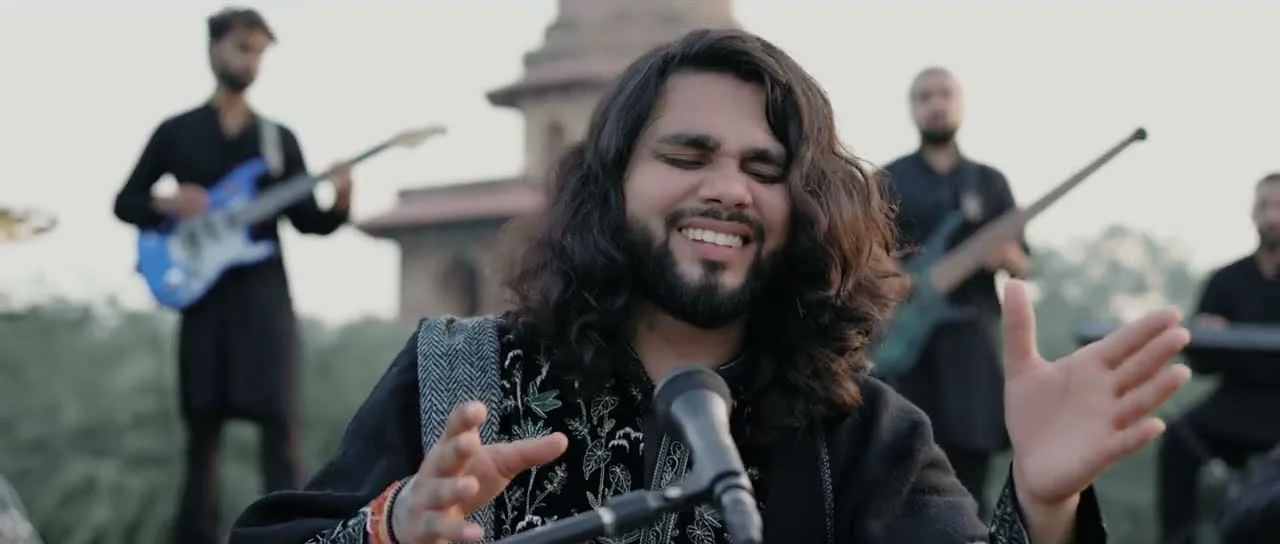 Softrock's vocalist with eyes closed, lost in the song, with electric guitarists behind.
