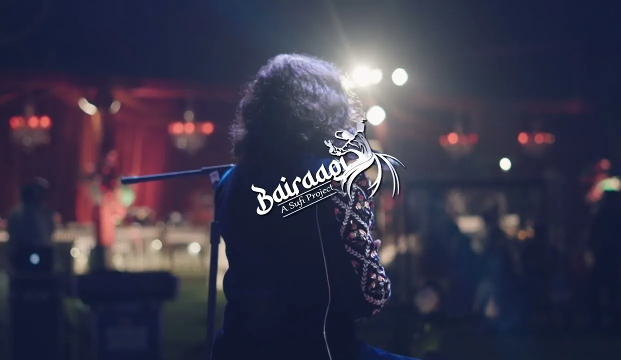 Softrock's vocalist seen from behind, facing a warmly lit night-time audience under chandeliers.