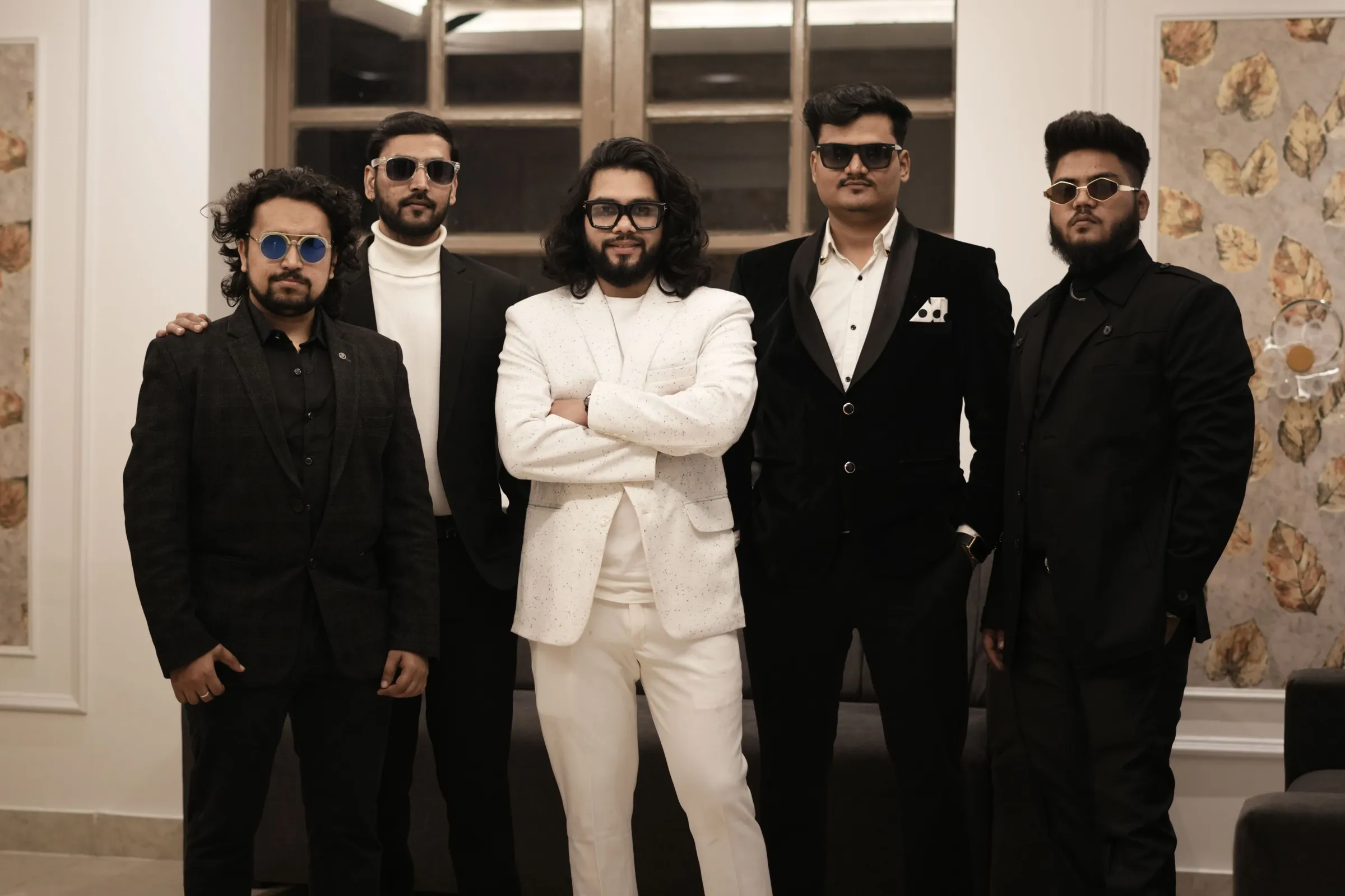 The five members of Softrock standing side by side in suits and sunglasses, the vocalist in the centre in white.