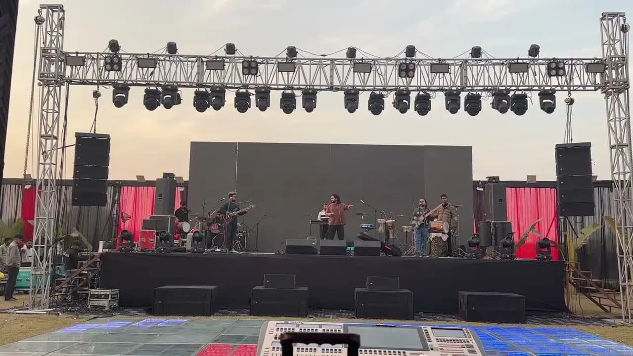 Softrock rehearsing on a large outdoor truss stage in daylight.