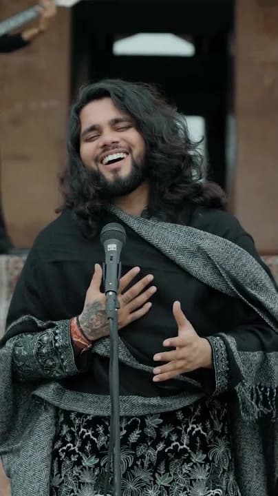 Softrock's vocalist in an embroidered shawl, hand on heart, smiling.