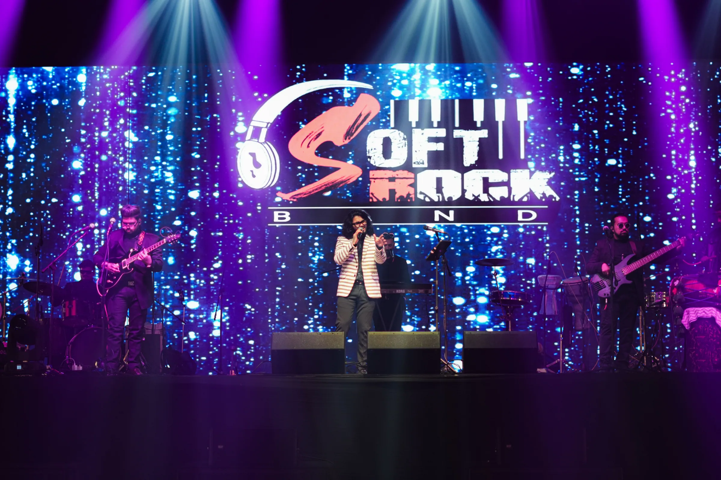 The full Softrock line-up on stage beneath a giant LED screen showing the Softrock Band logo.