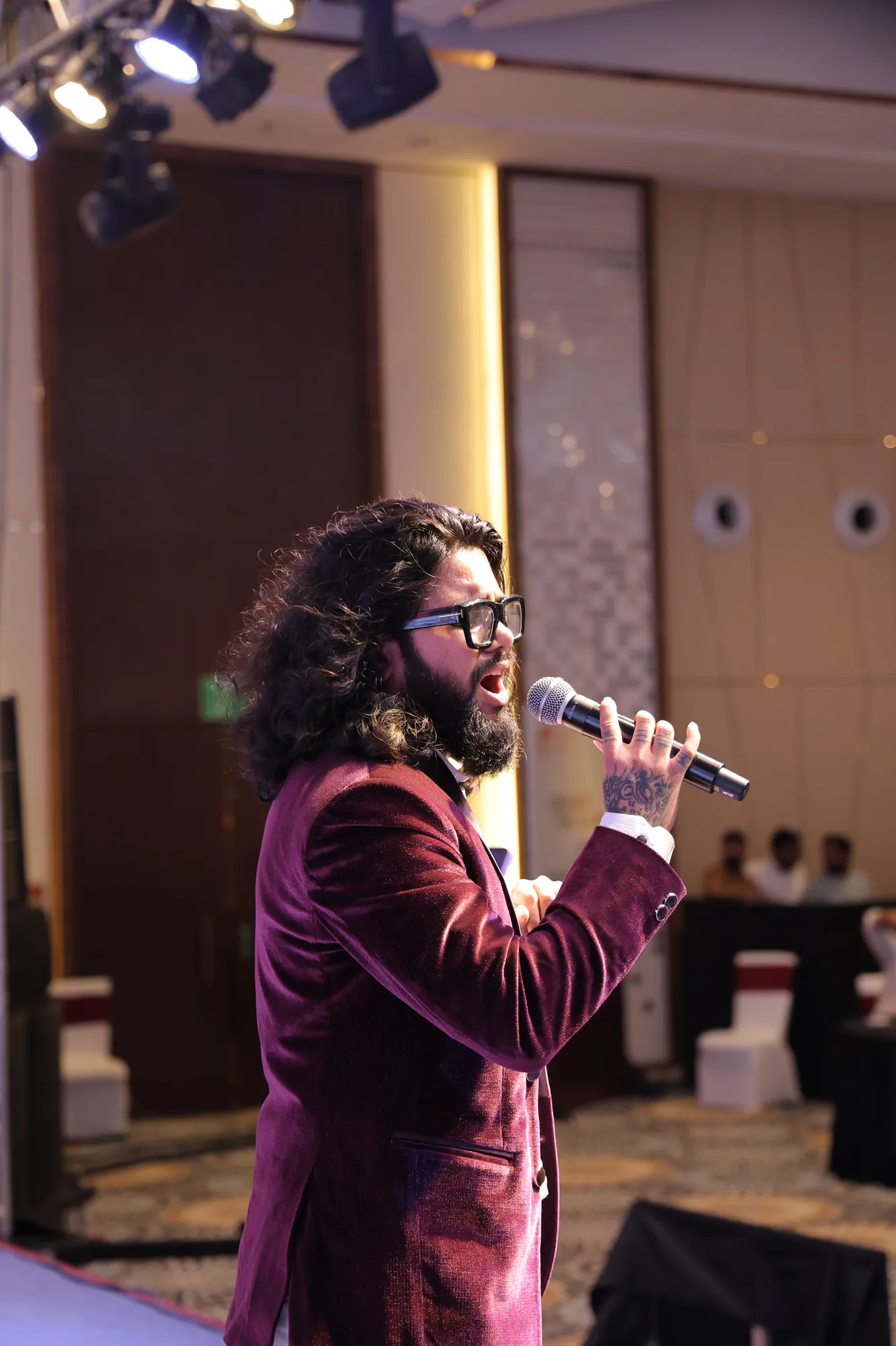 Softrock's vocalist in a maroon velvet jacket singing in a hotel ballroom.