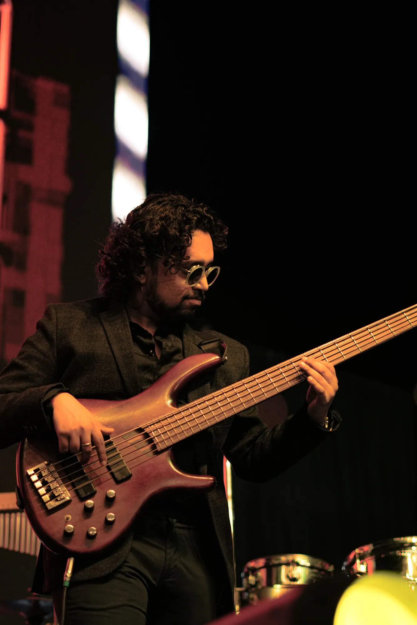 Softrock's bassist playing under a warm stage light.
